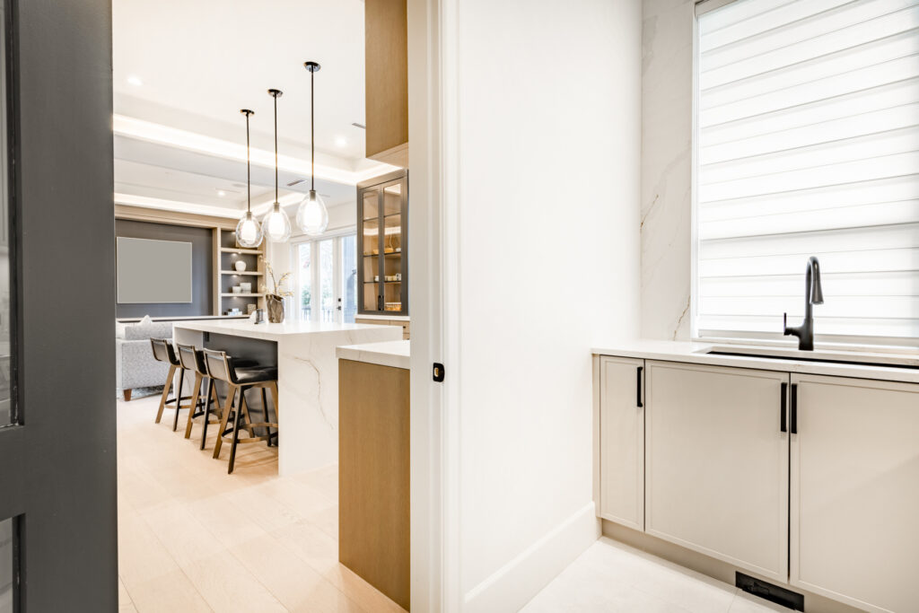 kitchen remodeling in Bethesda MD with pantry sink area, white cabinets, quartz countertops, and view toward open concept island kitchen