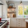 Bright modern kitchen from a full house renovation in McLean, VA, featuring white cabinetry, wood floating shelves, quartz countertops, and a large window with natural light.
